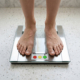 image of two feet standing on a scale where the display is pointing to a smiling green happy face icon