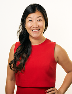 headshot image of Cat Sartin, COO, in red dress and white background